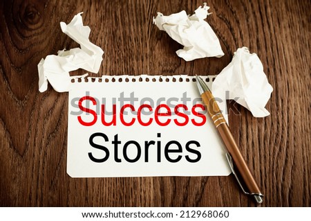 Success Stories Concept written on the paper on a wood table