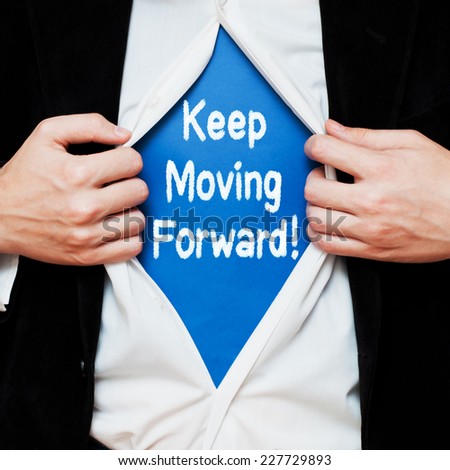 Keep Moving Forward. Businessman showing a superhero suit underneath his shirt with a motivational message text written on it.