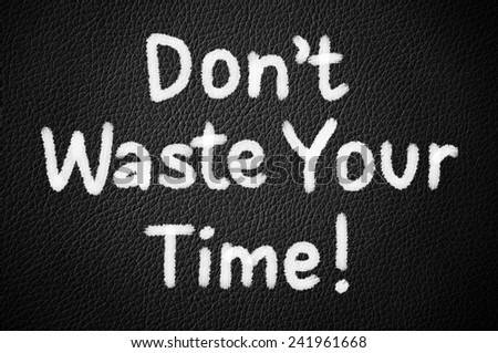 Don\'t Waste Your Time! written on a black leather texture