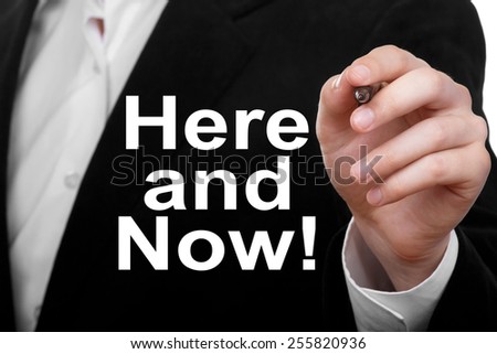 Businessman writing Here And Now Concept