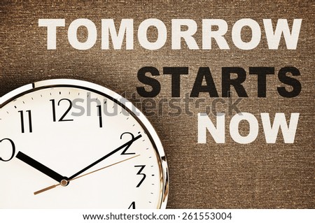 Tomorrow starts now written on a canvas with a clock face/ Motivation concept