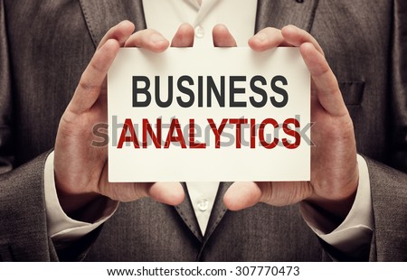 Business Analytics. Man holding a card with a message text written on it