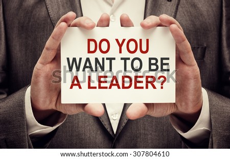 Do You Want to be a Leader? Businessman holding a card with a message text written on it.