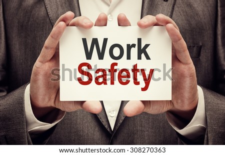Work Safety. Man holding a card with a message text written on it