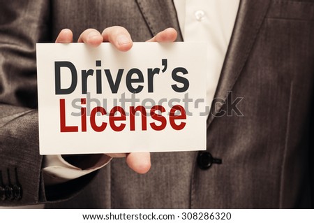 Drivers License. Man holding a card with a message text written on it