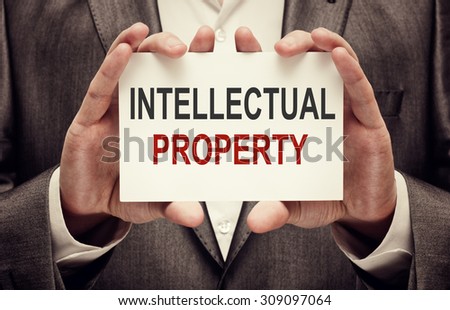 Intellectual property concept. Man holding a card with a message text written on it