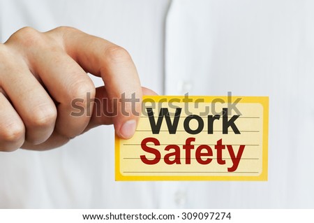 Work Safety. Man holding a card with a message text written on it