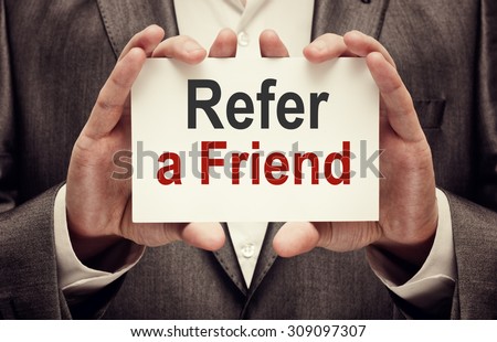 Refer a friend. Man holding a card with a message text written on it