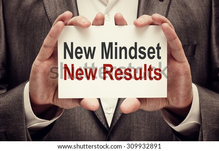 New Mindset New Results. Man holding a card with a message text