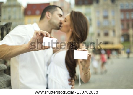 Kissing couple showing white card