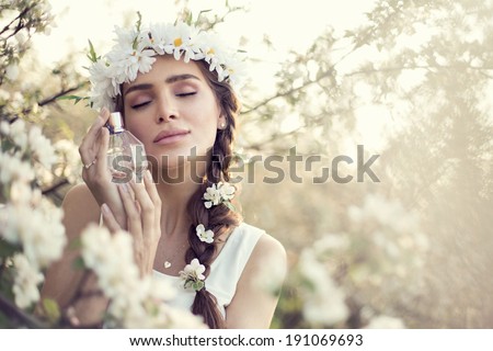 Beautiful sensual woman dreaming with perfume bottle in hands