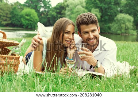 Happy couple on picnic drinking white wine