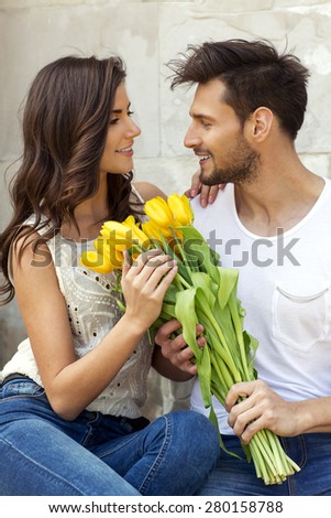 Loving couple. Man giving flowers her girlfriend