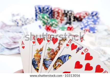 Poker hands - cards have focus with poker chips and money in background.