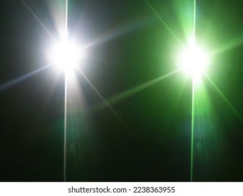 The​ black​ back​ground​ image​ has​ a​ white​ beam​ and​ a​ green​ beam​ of​ light​ shining​ through​ it​ for​ Graphics​