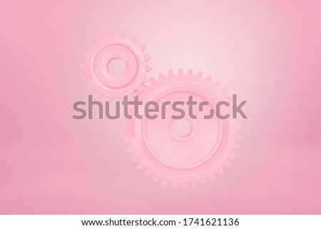 3d close-up rendering of two pink cogwheels floating on pink background. Tech support. Tools and machines. Team work.