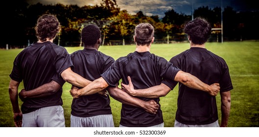 3D Cloudy sky against rugby players standing together before match - Powered by Shutterstock