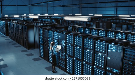 3D Computer Graphics: Big Data Center Female Chief Technology Officer Using Laptop Standing In Warehouse, Activates Servers, Information Digitalization Starts. SAAS, Cloud Computing, Web Service - Powered by Shutterstock