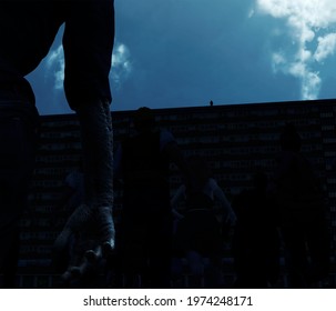 3d Illustration Of A Zombie Horde Running Toward A Black Of Flats At Night With The Silhouette Of A Figure Looking Down At Them From The Roof During A Zombie Apocalypse Or Viral Outbreak