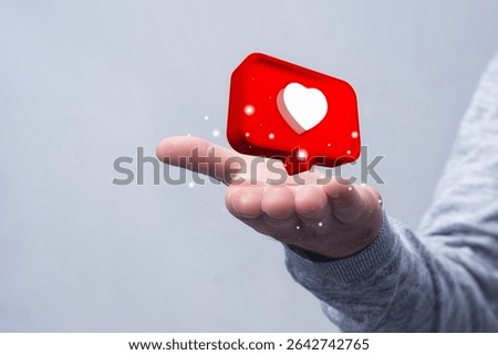 3D notification with heart icon levitates above a man open palm on a gray background. Concept social media endorsement, positive feedback and digital communication
