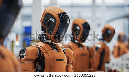 3D Render: Portrait of Orange AI-Enabled Humanoid Industrial Robot with Black Visor. Autonomous Humanoid Robots Stading in a Row on Conveor Line at Fullfilment Center.