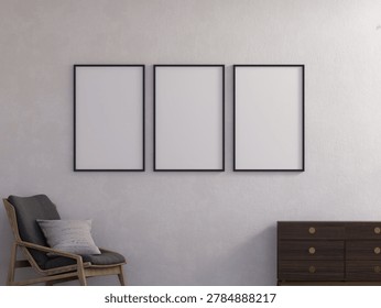 3D render of three blank vertical black photo frames mockup hanging on a grey textured wall in a modern Scandinavian-style living room. Interior scene includes a wooden armchair with pillow on the left and a dark wooden dresser with gold knobs on the right. Perfect for showcasing art prints, poster designs, photography, and wall decor presentations.