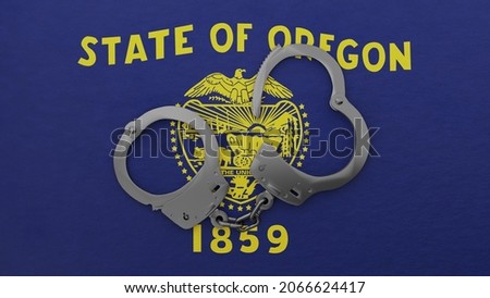 3D rendering of a half opened steel handcuff in center on top of the US state flag of Oregon (Front)