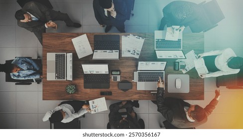 A 3D rendering illustration of a top-view modern office setup, featuring teamwork, laptops, and business collaboration.