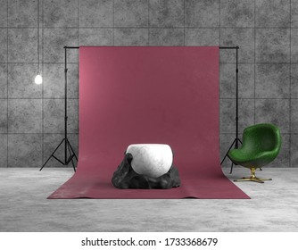 3D Rendering Interior Of A Photo Studio. Red Backdrop On A Tripod In A Concrete Room. Abstract Black And White Sculpture In The Form Of A Ball And Stone, Product Platform, Green Armchair Lit By Lamp.