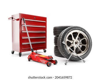 3D rendering of set of four tires, hydraulic car jack, lug wrench and red workshop tool cabinet on white - Powered by Shutterstock