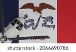 3D Rendering of a top down view of a White Helicopter in the Bottom Left Corner and on top of the US State Flag of Iowa