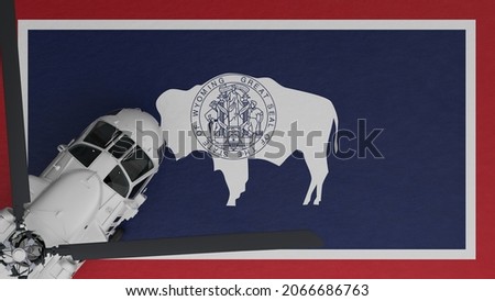3D Rendering of a top down view of a White Helicopter in the Bottom Left Corner and on top of the US State Flag of Wyoming