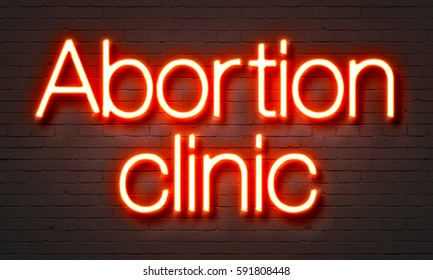 Abortion Clinic Neon Sign On Brick Wall Background