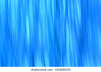 Abstract background blur in tints of blue through intentional camera movement.