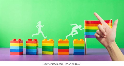 Abstract background and gender equality. Hand holding a rainbow flag beside a row of toy puzzle blocks concept of gender diversity and freedom of thought. Green, Pride, LGBTQ, Gay pride - Powered by Shutterstock