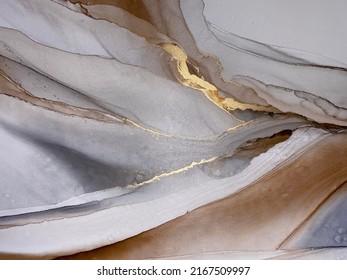 Abstract brown art with gold and gray — beige background. Beautiful smudges and stains made with alcohol ink and golden pigment. Brown fluid art texture resembles marble, watercolor or aquarelle.

