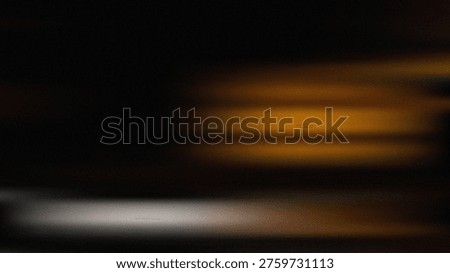 Abstract dark background with blurry horizontal streaks of warm and cool light