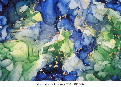Abstract fluid art painting background in alcohol ink technique, mixture of green, blue and gold paints. Transparent overlayers of ink create lines and gradients. Burst of creativity.