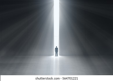 Abstract Man In Dark Concrete Interior With Glowing Doorway And God Light Rays Coming In. Business Concept. 3d Rendering