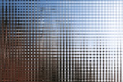 Abstract Of Riffled Glass Effect With Blue And Brown Background As If Looking Through Riffled Glass At An Urban Scene With A Blue Sky. 
