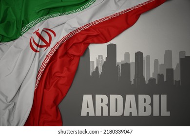abstract silhouette of the city with text Ardabil near waving colorful national flag of iran on a gray background.3D illustration