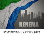 abstract silhouette of the city with text Kenema near waving colorful national flag of sierra leone on a gray background. 3D illustration