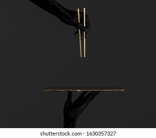 Abstract sushi bar concept background. Black hands using gold chopsticks and sushi dish isolated on black, 3d illustration. - Powered by Shutterstock