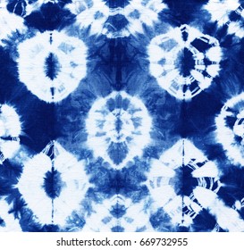 Abstract tie-dyed pattern of indigo color on white cotton. Hand painted fabrics. Shibori dyeing, batik