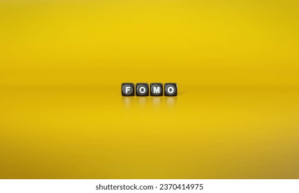 Acronym ‘FOMO’ or ‘Fear of Missing Out’ spelled out in white text on dark wooden blocks against plain yellow background. 3D rendering