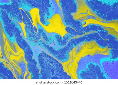 Acrylic Fluid Art. Free Flow Of Yellow And Blue Colors Creates Marble Effect. Abstract Background Or Texture.