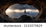 Adult Woman Hiker standing in a rocky cave. Dramatic Colorful Sunset. 3d rendering. Aerial Background Landscape Image from British Columbia, Canada. Adventure Concept