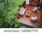 Aerial view of modern contemporary style small wooden terrace in lush garden with 3d render, decorated with white outdoor furniture and string light