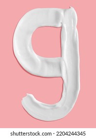 Alphabet Letter G Handwritten, White Cream Moisturiser Texture Smear Stroke Isolated On Pink Background
