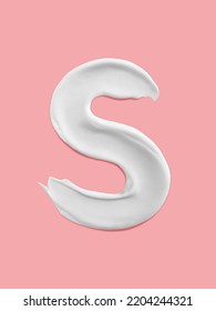 Alphabet Letter S Handwritten, White Cream Moisturiser Texture Smear Stroke Isolated On Pink Background
